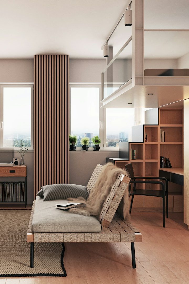 Aménagement espace optimisé - Intësia Design Nantes Intérieur moderne avec un canapé, un bureau, des plantes et de grandes fenêtres.