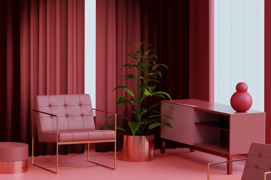 Espace intérieur aux tonalités rouges - Intësia Design Nantes Intérieur moderne avec fauteuil, plante verte et mobilier rouge.