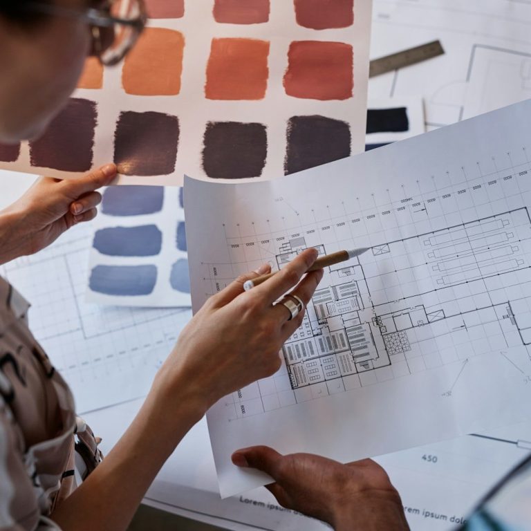 Personne analysant des échantillons de couleurs et des plans architecturaux.