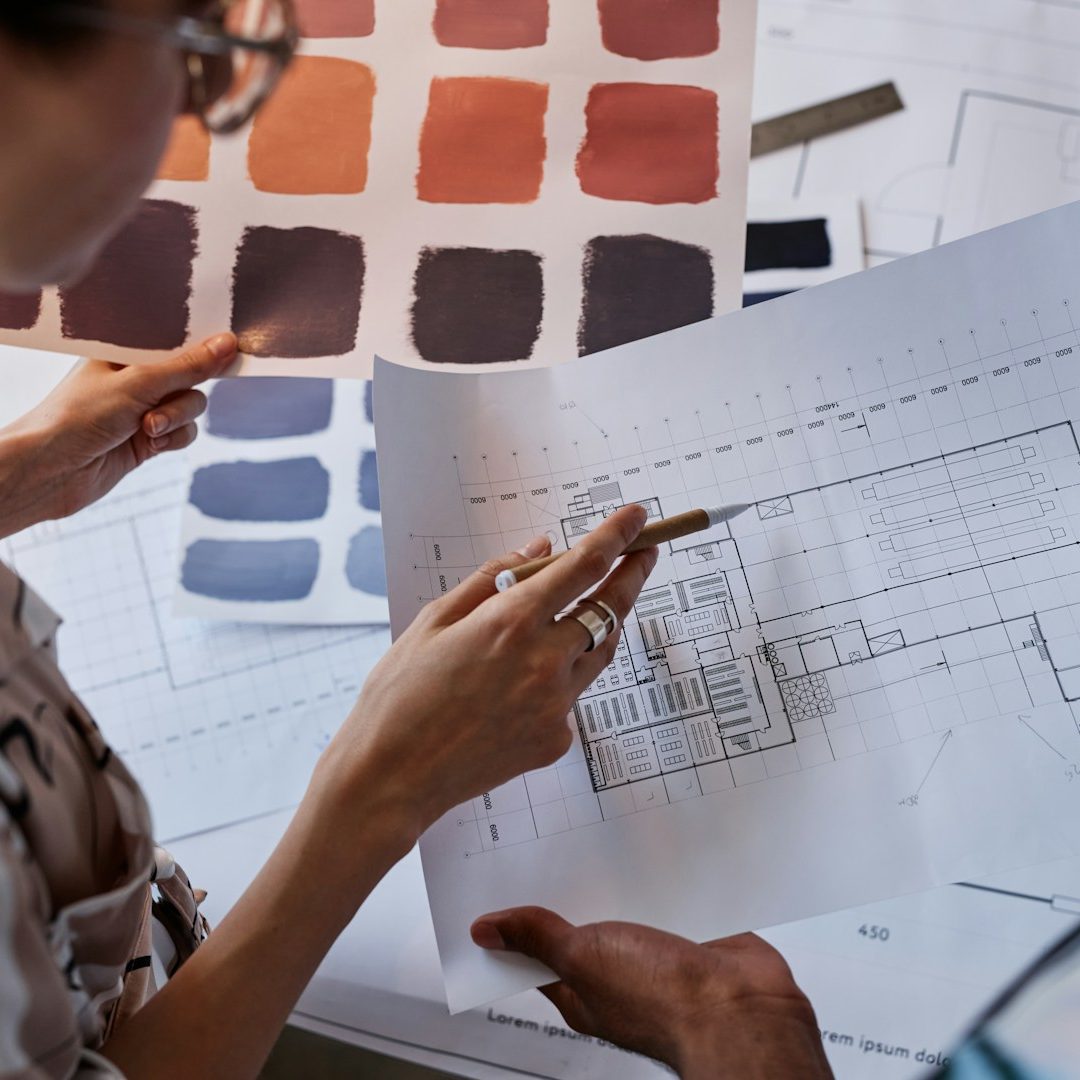Une personne examine des plans et des échantillons de couleur pour un projet de design.